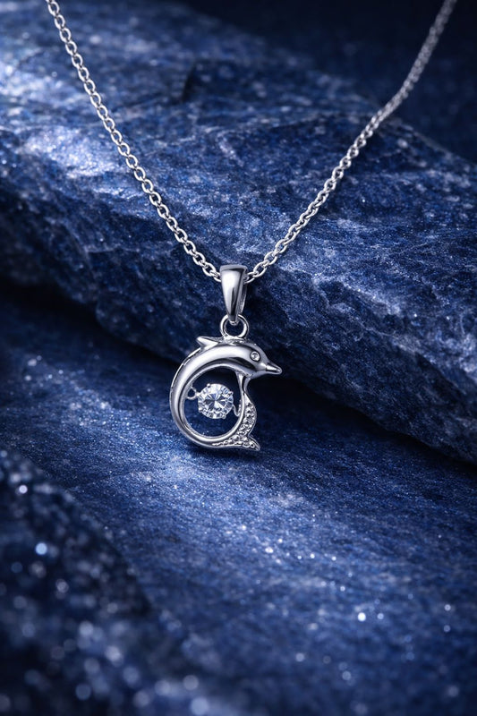 Luvina silver dolphin pendant necklace on dark blue stone background