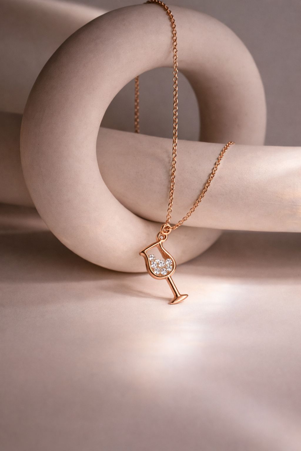 Close-up of rose gold wine glass pendant necklace with crystals